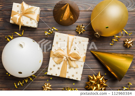 Holiday background with colorful balloon, gift and confetti. Flat lay style. Birthday or party greeting card with copy space Holiday background with colorful balloon, gift and confetti. Flat lay style. Birthday or party greeting card with copy space 112960384