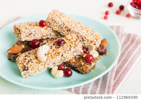 Various granola bars on table background. Cereal granola bars. Superfood breakfast bars with oats, nuts and berries, close up. Superfood concept 112960390