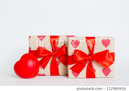 gift box with red bow and red heart on colored background. Perspective view. Flat lay gift box with red bow and red heart on colored background. Perspective view. Flat lay 112960416
