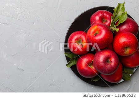 Many red apples on cement background, top view. Autumn pattern with fresh apple above view Many red apples on cement background, top view. Autumn pattern with fresh apple above view 112960528