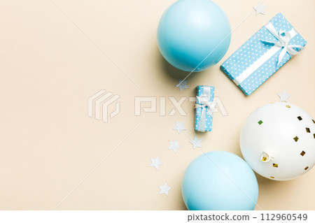 Holiday background with colorful balloon, gift and confetti. Flat lay style. Birthday or party greeting card with copy space 112960549