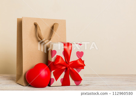 Shopping bag with gift box on colored background perspecrive view. Space for text holiday concept 112960580