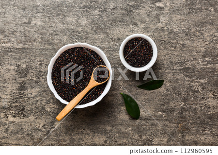 quinoa seeds in bowl and spoon on colored background. Healthy kinwa in small bowl. Healthy superfood 112960595