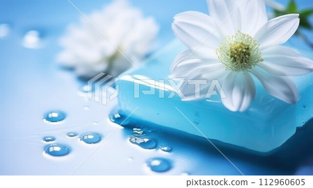 AI-generated content. Light-blue transparent natural soap with water drops and white flower on a blue wet glossy surface, close-up, copy space, selective focus. 112960605