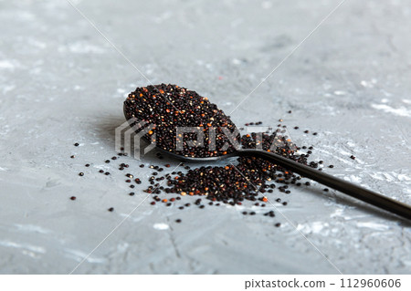 quinoa seeds in spoon on colored background. Healthy kinwa in small spoon. Healthy superfood quinoa seeds in spoon on colored background. Healthy kinwa in small spoon. Healthy superfood 112960606