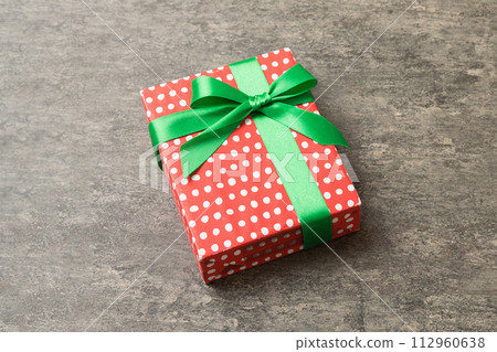 Wrapped christmas or other holiday handmade present in paper with colored ribbon. Present box, decoration of gift on table, top view with copy space Wrapped christmas or other holiday handmade present in paper with colored ribbon. Present box, decoration of gift on table, top view with copy space 112960638
