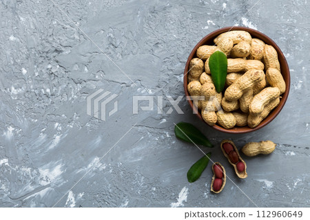 Fresh healthy peanuts in bowl on colored table background. Top view Healthy eating bertholletia concept. Super foods Fresh healthy peanuts in bowl on colored table background. Top view Healthy eating bertholletia concept. Super foods 112960649