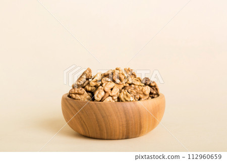 Fresh healthy walnuts in bowl on colored table background. Top view Healthy eating bertholletia concept. Super foods Fresh healthy walnuts in bowl on colored table background. Top view Healthy eating bertholletia concept. Super foods 112960659