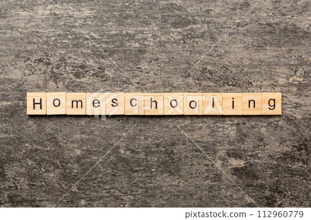 Home schooling word written on wood block. Homeschooling text on table, concept 112960779