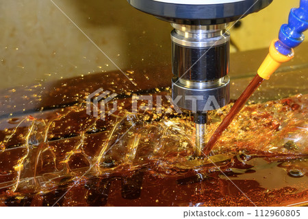 The CNC milling machine rough cutting the mold parts with liquid coolant method. 112960805