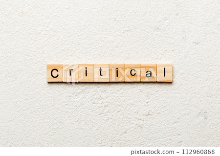 critical word written on wood block. critical text on table, concept critical word written on wood block. critical text on table, concept 112960868