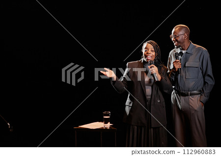Portrait of two African American performers on dark stage with spotlight, copy space Portrait of two African American performers on dark stage with spotlight, copy space 112960883