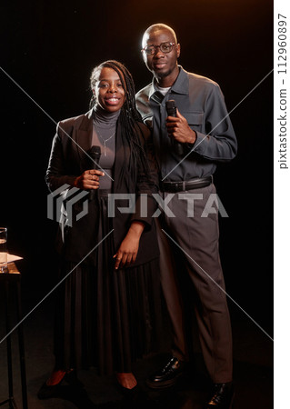 Portrait of two African American couple performing on stage together with spotlight 112960897