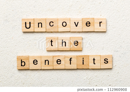 uncover the benefits word written on wood block. uncover the benefits text on table, concept 112960908