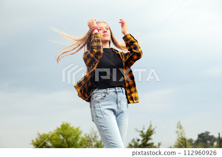 Smiling happy girl. Portrait preteen girl on the gray sky backgr 112960926