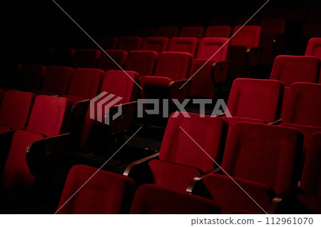 Graphic background image of empty seat rows in audience at theater with low light copy space Graphic background image of empty seat rows in audience at theater with low light copy space 112961070