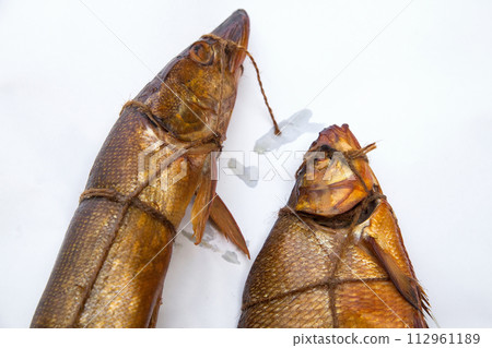 Smoked freshwater pike and common bream fish for home use on white paper.. 112961189