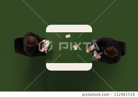 Creative collage. Overhead view of two people, man playing cards at table, set against dark green background. Copy space. Ad 112961518
