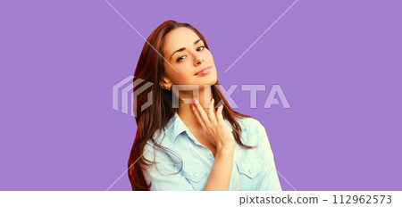 Portrait beautiful young brunette woman model posing on purple studio background 112962573