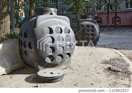 Plastic communication wells at a construction site for road repair work on a city street 112962927