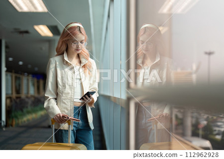 Traveler woman asian in airport and luggage for vacation, smile and talking on the phone check boarding ticket. Female traveler with suitcase, international and departure with passport and trip Traveler woman asian in airport and luggage for vacation, smile and talking on the phone check boarding ticket. Female traveler with suitcase, international and departure with passport and trip 112962928