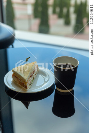 Paper cup of coffee and sandwich in the garden 112964611