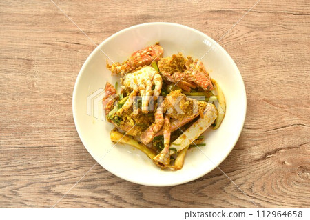 stir fried swimmer crab in yellow curry and egg on plate  112964658