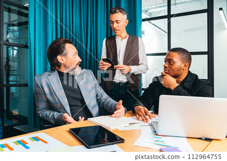 Team of people work together on company statistics in office Team of people work together on company statistics in office 112964755