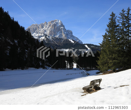 Timber bench with view of the Langkofel, mountain in South Tirol. 112965303