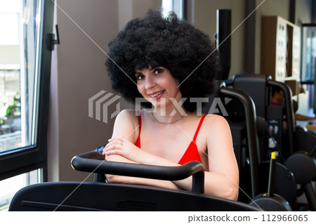 Woman athlete with curly hair extensions, interesting creative hairstyle 112966065
