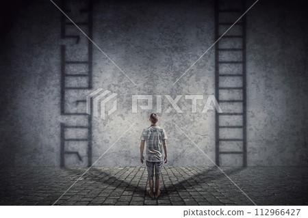 Person stands in front of a wall casting two ladder shadows with one broken on the left and another ready to use on the right. Dilemma and choice concept between good and bad 112966427
