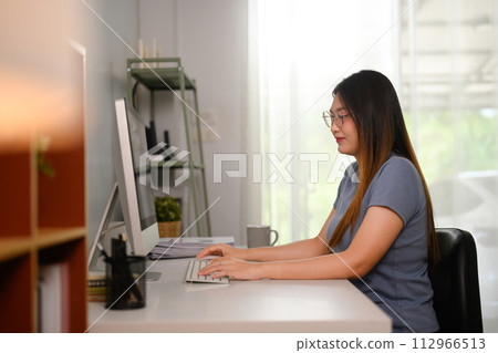 Young Asian woman freelancer working on computer on table at home office Young Asian woman freelancer working on computer on table at home office 112966513