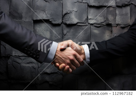Two business people shake hands, symbolizing a successful deal. Close-up of a handshake. 112967182