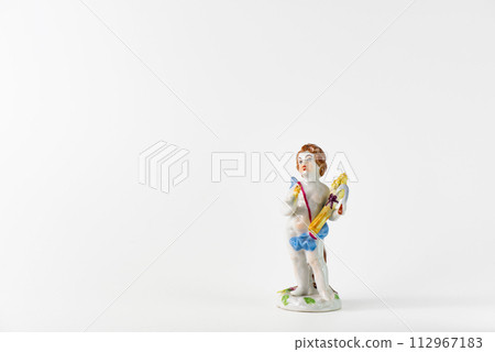 Antique ceramic angel looking up with downcast eyes 112967183