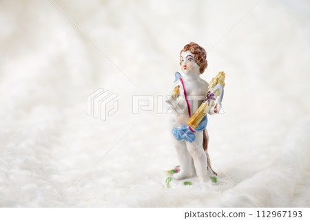 Antique angel doll placed on soft fur fabric 112967193