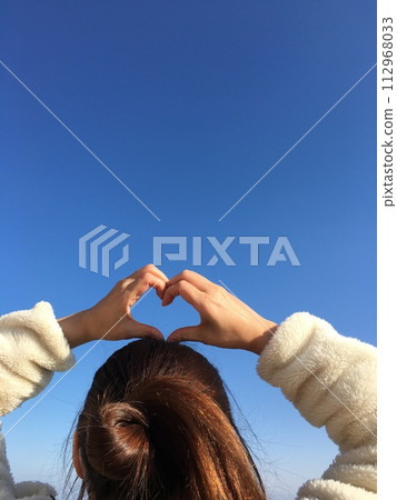 一個女人握著她的手反對藍天 一個女人握著她的手反對藍天 112968033