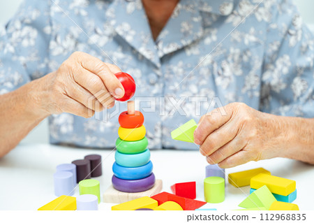 Alzheimer disease AD, Asian elderly woman patient suffering from dementia learn practical motor skills rehabilitation. Alzheimer disease AD, Asian elderly woman patient suffering from dementia learn practical motor skills rehabilitation. 112968835