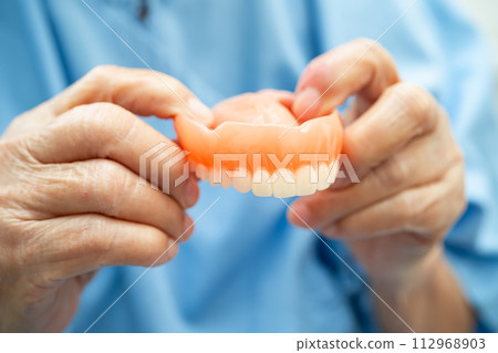Asian elderly woman patient holding to use denture, healthy strong medical. 112968903