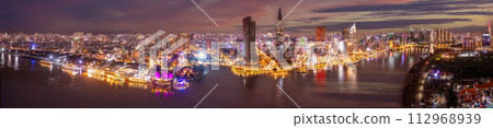 Aerial panoramic cityscape view of HoChiMinh city and the River Saigon, Vietnam with blue sky at sunset. View from Thu Thiem peninsula 112968939