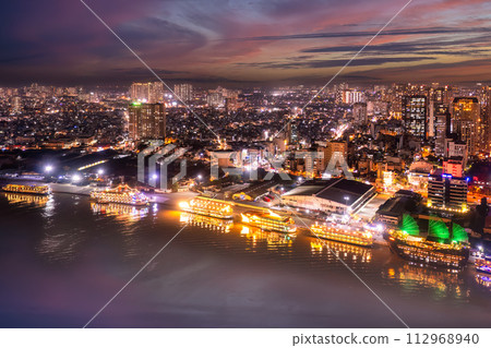 Aerial panoramic cityscape view of HoChiMinh city and the River Saigon, Vietnam with blue sky at sunset. View from Thu Thiem peninsula 112968940