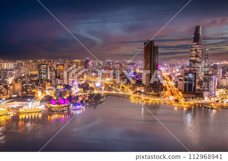Aerial panoramic cityscape view of HoChiMinh city and the River Saigon, Vietnam with blue sky at sunset. View from Thu Thiem peninsula 112968941