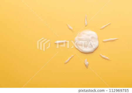 Sunscreen cream texture in sun shape on yellow background. SPF sunblock cream for protect against wrinkles, discoloration and skin cancer. Daily skincare products for sun protection. Sunscreen cream texture in sun shape on yellow background. SPF sunblock cream for protect against wrinkles, discoloration and skin cancer. Daily skincare products for sun protection. 112969785