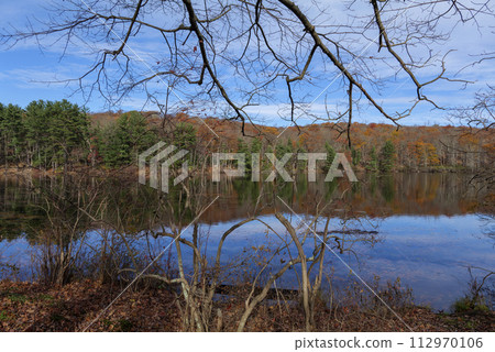 Autumn lake reflecting on a blue sky background and forest landscape Autumn lake reflecting on a blue sky background and forest landscape 112970106