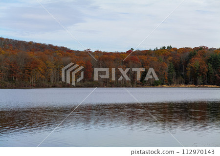 Autumn lake reflecting on a blue sky background and forest landscape Autumn lake reflecting on a blue sky background and forest landscape 112970143