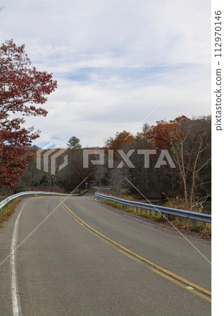 On a sunny cloudy day, the road along the lake in Upstate New York. 112970146