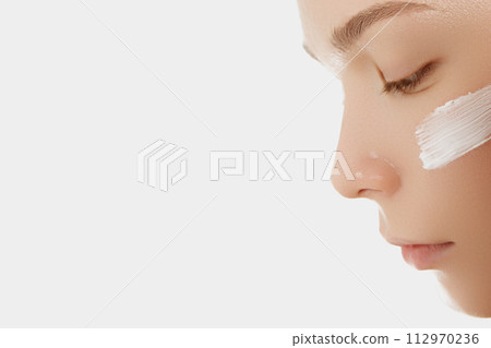 Face skin care. Woman applying cosmetic cream on 112970236