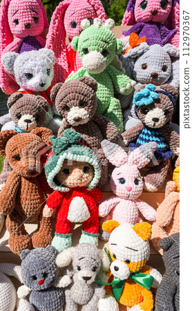 Various knitted colorful soft toys at the outdoors 112970367