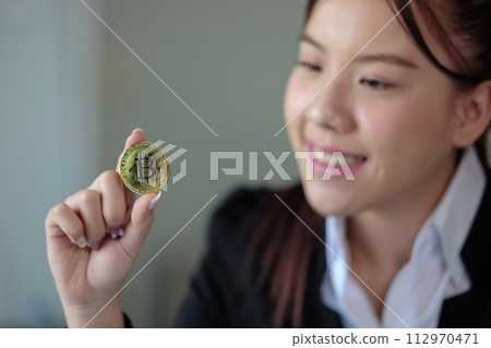Business woman look at Bitcoin btc cryptocurrency as saving bank account currency in finance exchange trade for digital money gold technology cash. Person invest in electronic online payment market 112970471
