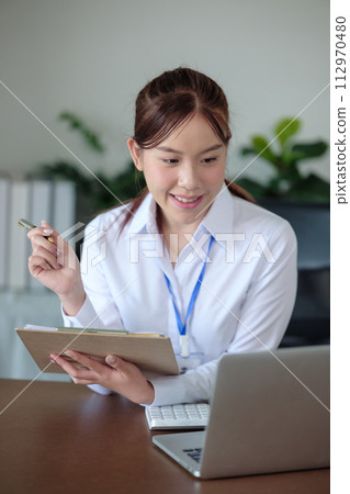 Portrait of beautiful asian young Business woman working audit and calculating expense annual financial report balance sheet statement,doing finance making notes on paper graph data checking document. Portrait of beautiful asian young Business woman working audit and calculating expense annual financial report balance sheet statement,doing finance making notes on paper graph data checking document. 112970480