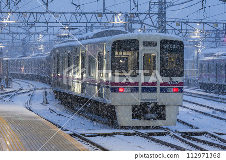 Limited express train running in the snow, Keio Line, Snowy day, Takahatafudo Station 112971368